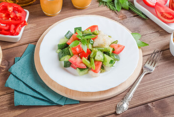 Healthy food - fresh vegetable salad with beans and cauliflower in a white plate on a dark wooden background