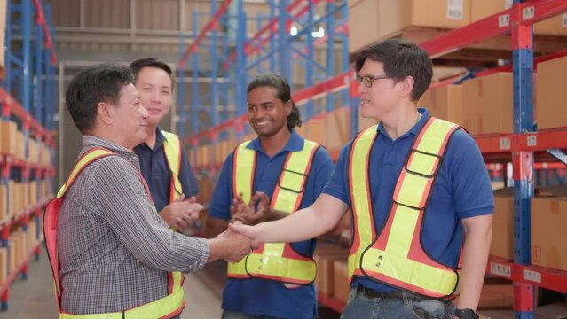 Professional, Unity and teamwork of group warehouse workers in factory storehouse. Manager handshake with foreman or employee standing together celebrate cheerful success with colleague happy smile.