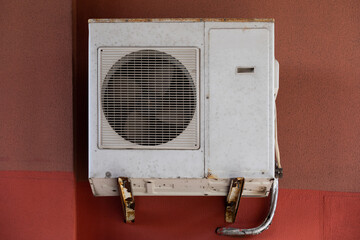 old outdoor air conditioner unit hanging outside the building