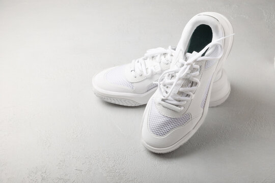  White sneakers on a white background.Fashion.UNISEX. Sneakers are sports shoes for an active lifestyle. Product photo and levitation concept. Street style. Copy space. Place for text.