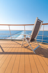 Vue d'une chaise longue sur le pont d'un navire de croisière dans le sillage d'un navire de croisière. Vue depuis la poupe du navire.	