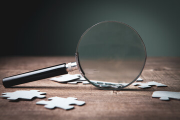 a magnifying glass and puzzle pieces on the table