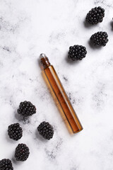 Cosmetic bottle of perfume and blackberries. Concept of expensive perfume and cosmetics. Women's and men's essence.