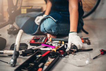 Close up repairman mechanic working in bicycle repair shop with bike tools and part, bike...