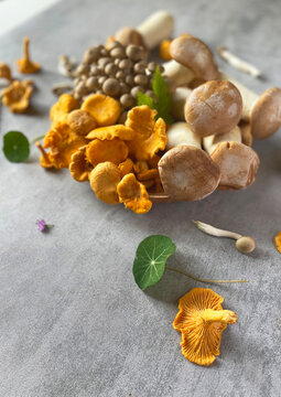 Mushrooms on a wooden cutting board and black borad on the table. 