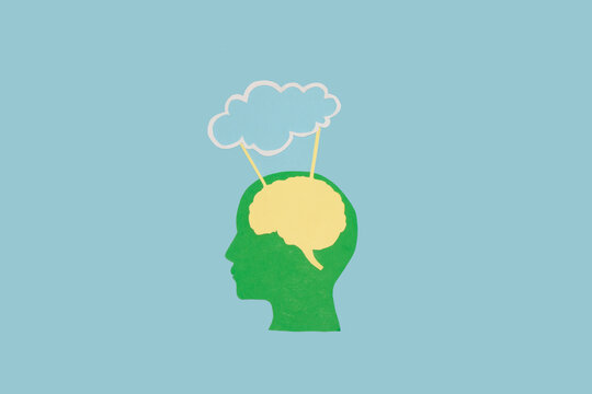 green paper head with brain connected to cloud as copy space on blue background, creative art design, technology and humanity
