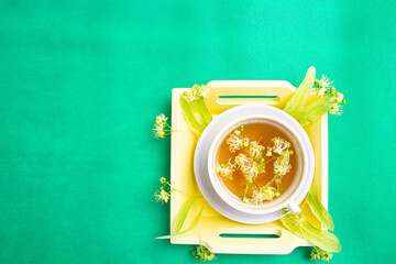 linden tea in a mother-of-pearl cup with linden flowers