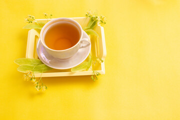 linden tea in a mother-of-pearl cup with linden flowers