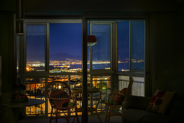 Silhouette rattan chairs in a holiday terrace in a property with cityscape at night