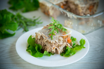jellied meat with greens and vegetables in a plate