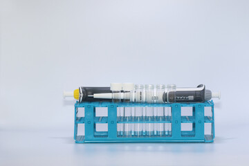 automatic pipette, beaker and test tubes in rack on white background