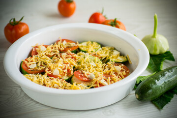 raw zucchini and tomatoes sliced with cheese, prepared for baking
