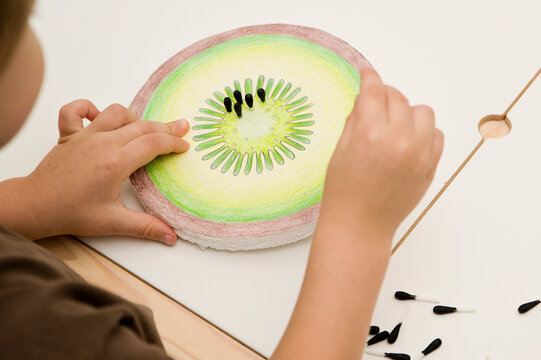 Slice Of Kiwi Fruit. DIY Home Made Paper Toy. Seeds Made Of Black Painted Cotton Buds. Activities At Home. Insert The Pin. Implement For Special Needs Children And Fine Motor Activities For Preschool