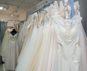 White and cream wedding dresses on a hanger in a bridal boutique