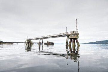 Old derelict wooden jetty pier in sea at Inverkip power station