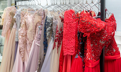 Multicolored wedding and evening dresses on a rack in a bridal shop