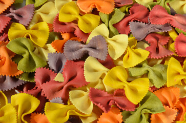 colorful farfalle pasta with natural extracts food background close up