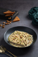 Indian sweet Nawabi Shahi Tukra with cashew served in a dish isolated on dark background side view food