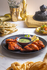 Peshawari Chicken with chutney, raita, lime, salad and roti served in a dish isolated on dark background side view food