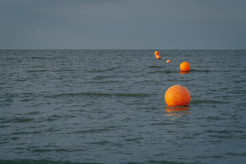 Off shore wind farm with orange buoys in foreground