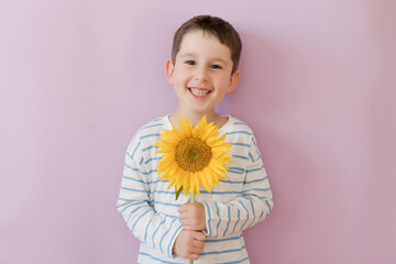 Boy with sunflower on pink background