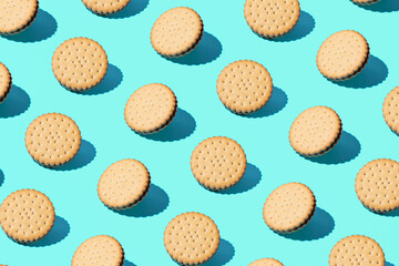 Old fashioned sandwich cookies, creative food pattern on mint blue background.