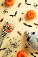 Halloween creepy decorations concept. Top view vertical photo of skull skeleton hands pumpkins bat...