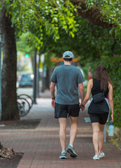 Obraz premium couple holding hands walk through the streets of miami coconut grove
