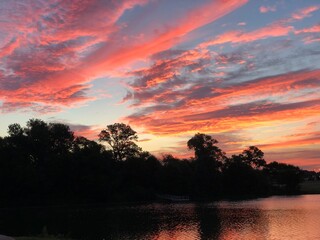 Gorgeous streaks of sunrise clouds in the skies reflected in the lake
