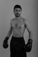 Fototapeta na wymiar Training of a young strong boxer in black and white