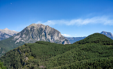 forested canyon and gorge in a mountain range, clear blue summer sky