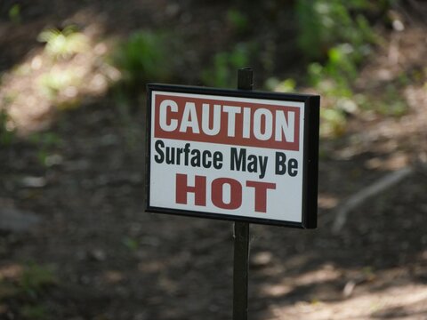 Roadside sign caution "Surface may be hot"