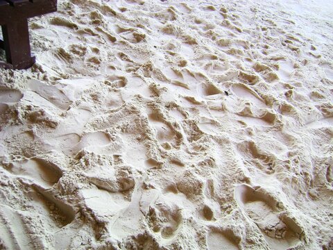 Soft, white sand with multiple footprints