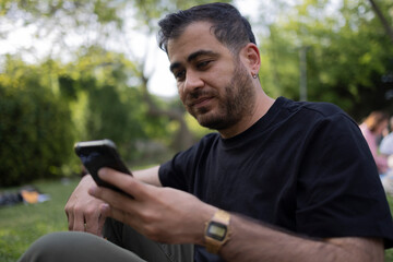 Using mobile phone at open air. Texting, socializing on internet and social media concept photo. 