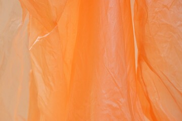 Blurred a colorful orange color of a raincoat for background backdrop 