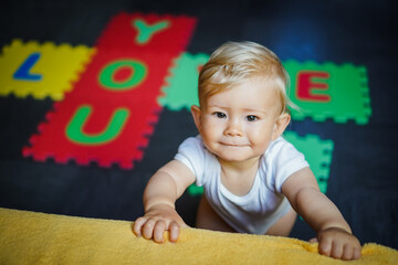 bird view of colorful kids puzzle mat playground in nursery with letters like Baby Love written on...