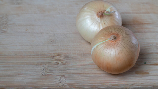 Onions in husks on a wooden board vegetables background