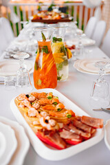 table served. jugs with lemonade and dried meat and tartlets