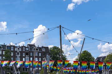 Celebration of pride month in Amsterdam: Rainbow flag hanging outside a building along a street,...