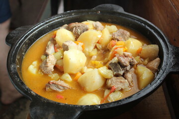 stewed potatoes with vegetables and shurpa meat in a close-up cauldron. Homemade food. Food in nature. delicious national dish