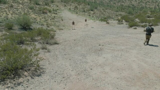 Man Shooting  Pistol at Firing Range Aerial Drone 4k Footage outside in Arizona Desert on Sunny Day