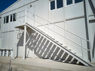 Metal stairway outside of mobile industrial building. Newly built two-storey prefabricated...