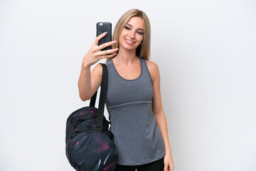 Fototapeta premium Young sport woman with sport bag isolated on white background making a selfie