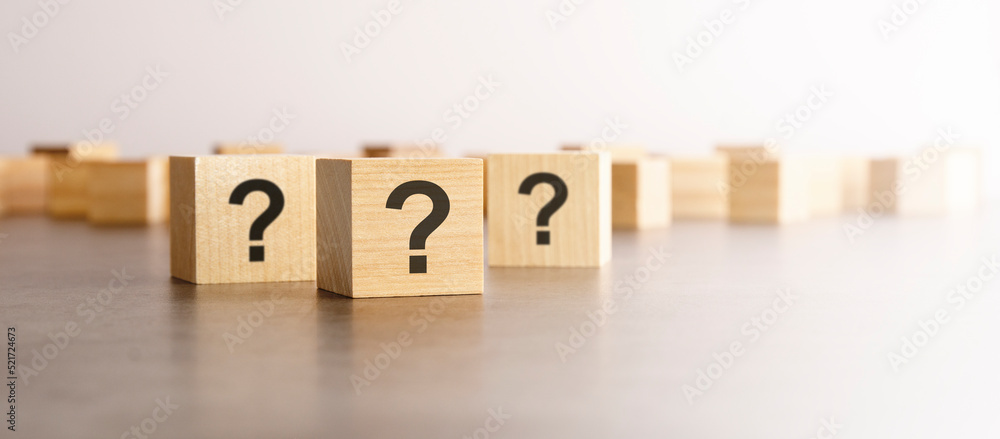 Poster front view on many wood cubes with question marks. many question arising concept