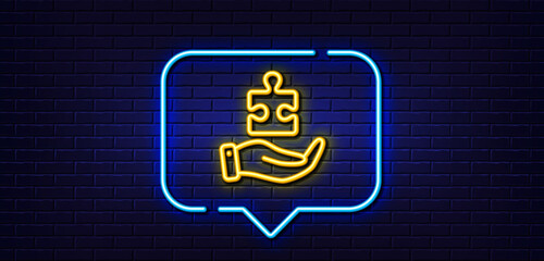 Neon light speech bubble. Puzzle line icon. Hand with Jigsaw piece sign. Business challenge symbol. Neon light background. Puzzle glow line. Brick wall banner. Vector