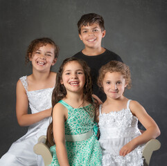 Portrait four mixed race school age brother and sisters with toddler little sister - 521728255