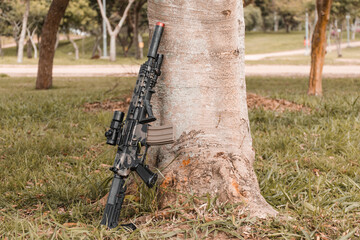 Airsoft rifle leaning against a tree