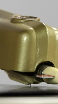 Vintage record player turntable spinning with needle dropping on vinyl disk.  Vertical video.
