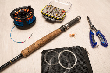 A collection of fly fishing paraphernalia on a white background with copy space