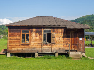 Wooden house on the lawn. Working hut. Place for an overnight stay. Village building.